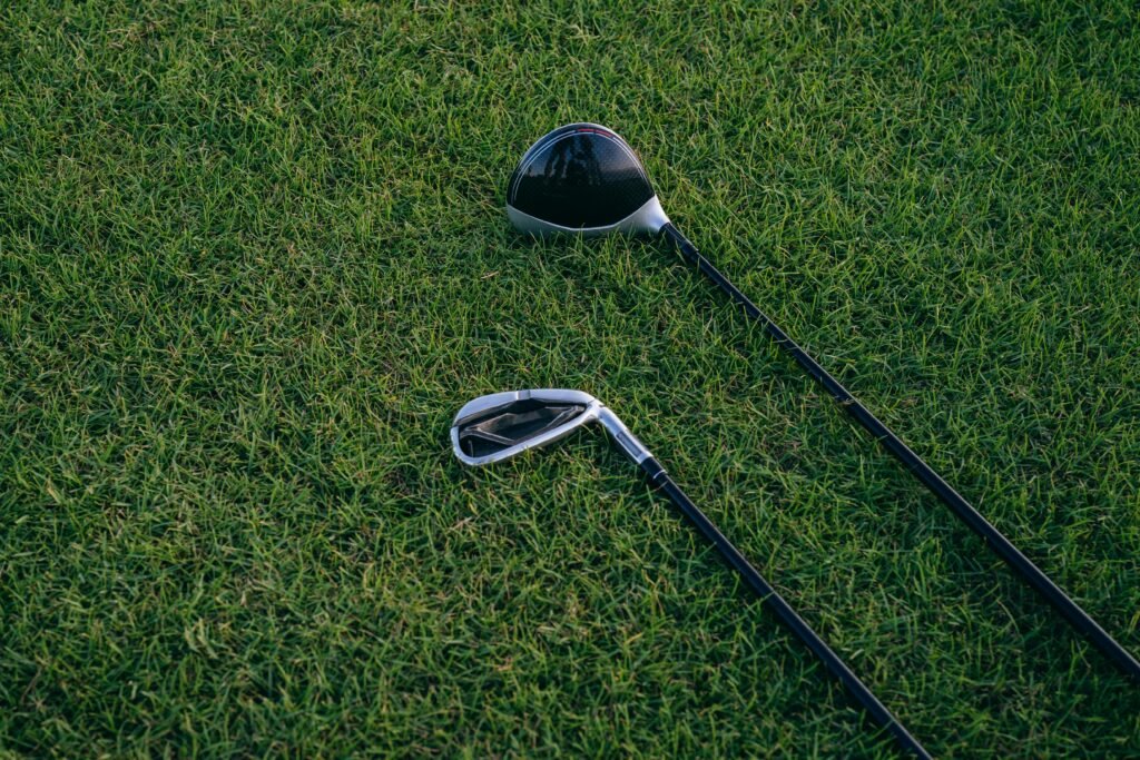 A close-up view of two golf clubs resting on neatly manicured grass, perfect for golf enthusiasts.